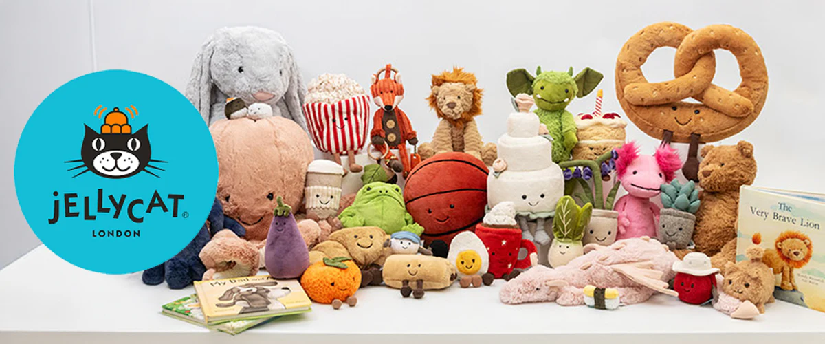 A colorful collection of Jellycat London plush toys including animals, food characters, and novelty items arranged on a white shelf